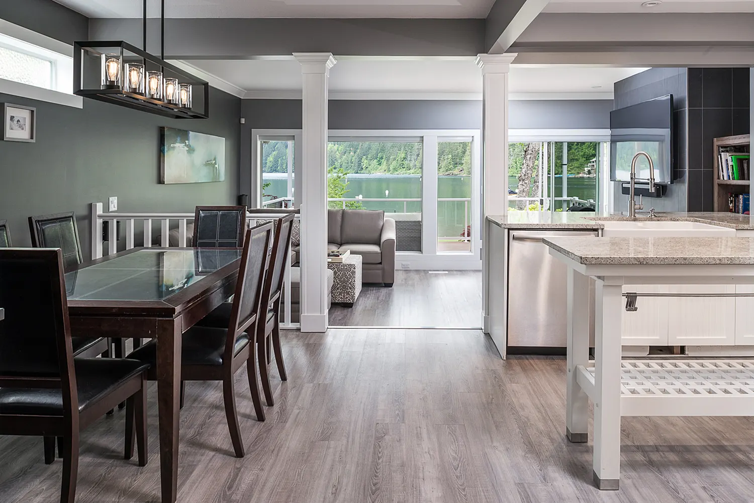 Bright open-concept kitchen and dining room with wood floors in the renovated Cultus Lake home