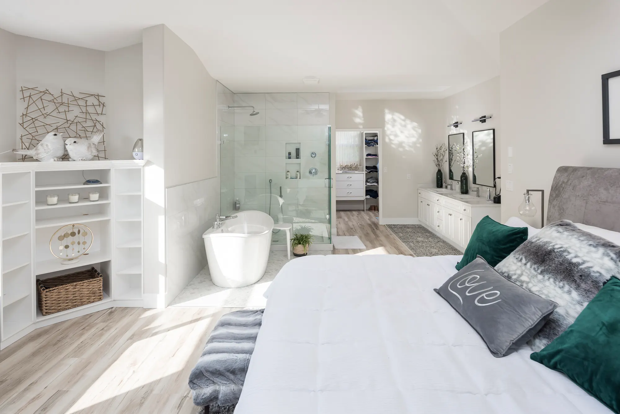Modern primary suite with a freestanding tub and frameless glass shower after renovation